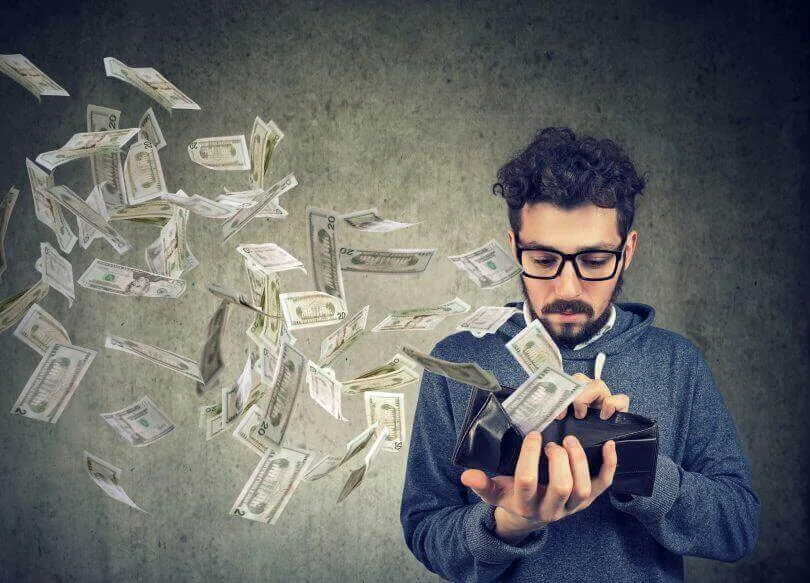 Man holding a wallet with currency notes around him